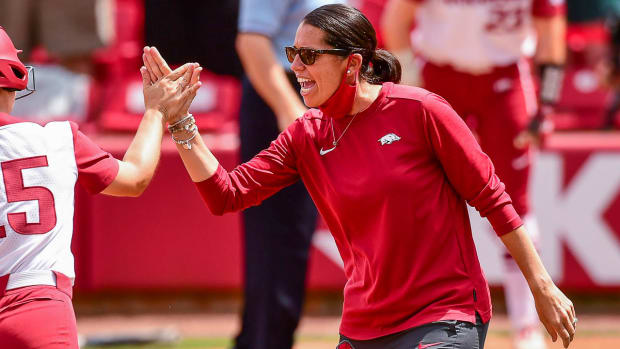 Courtney Deifel high fives one of her Arkansas Razorbacks players.